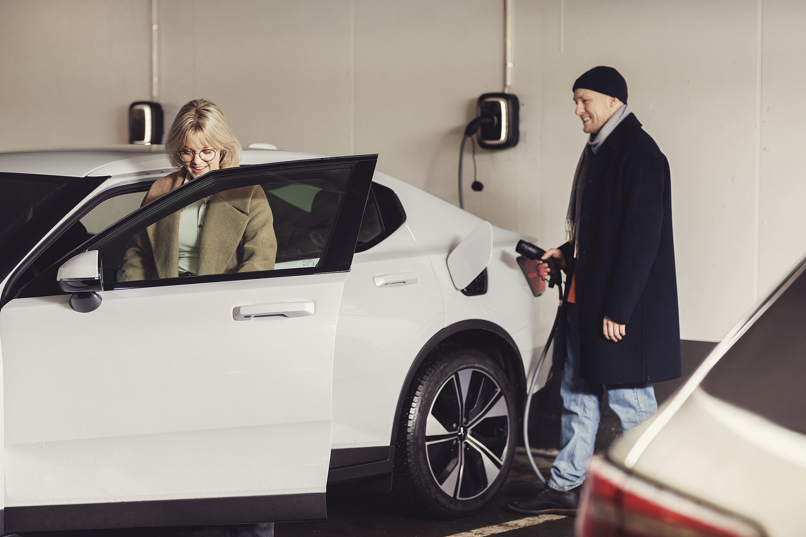 A driver plugging the cable into an EV at an Enua charger — charging starts automatically